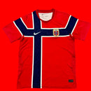 PUSKAS IMPORTS Norway 2026 World Cup home soccer jersey. Red with navy blue cross and white trim.